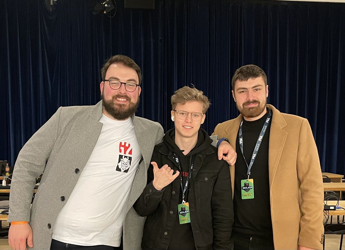 Joakim standing backstage between two much taller people at the Stockholm Major.